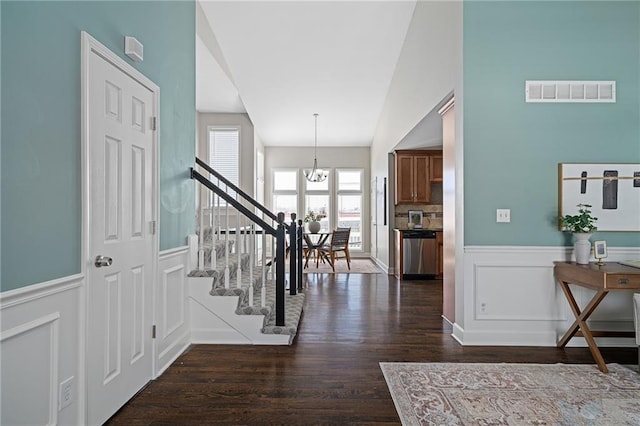 foyer with dark wood-type flooring and a chandelier