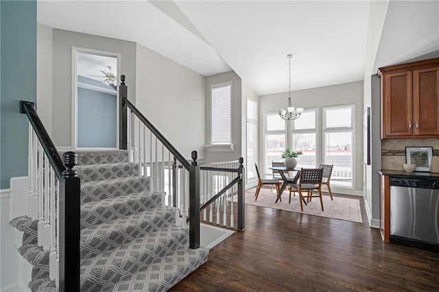 staircase with a notable chandelier and hardwood / wood-style flooring