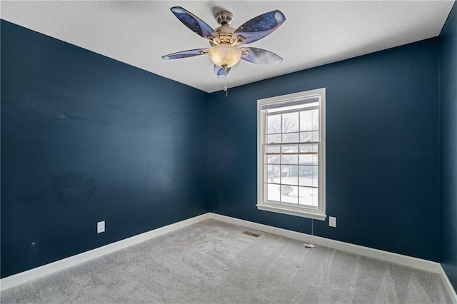 empty room featuring a textured ceiling, carpet floors, and ceiling fan