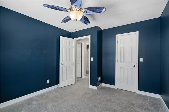 unfurnished bedroom with ceiling fan and light colored carpet