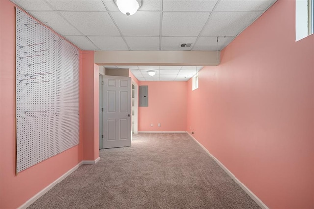 basement with a paneled ceiling, electric panel, and carpet floors