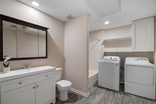 interior space featuring separate washer and dryer, sink, a textured ceiling, and light wood-type flooring