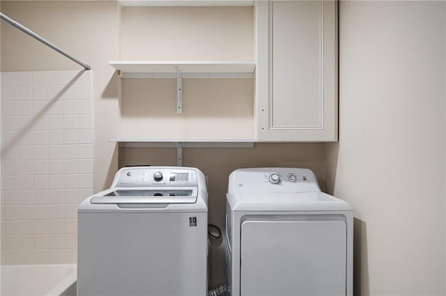 laundry area featuring washing machine and dryer and cabinets