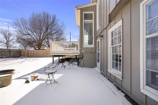 snow covered patio featuring a wooden deck