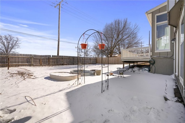 snow covered patio featuring a wooden deck