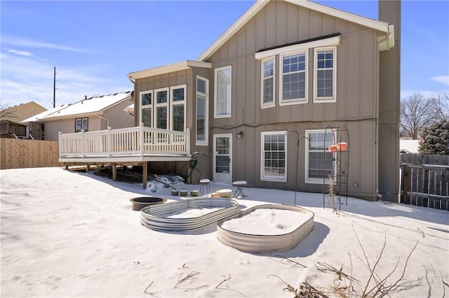 snow covered house featuring a deck