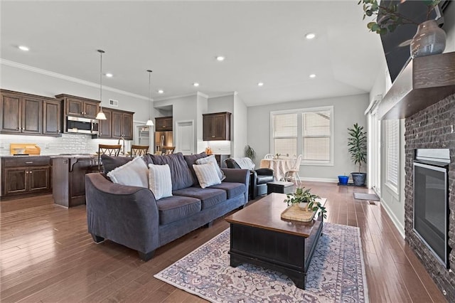 living room featuring a fireplace, baseboards, dark wood-style flooring, and ornamental molding