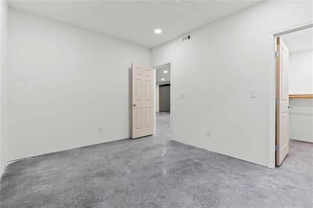 unfurnished bedroom with a spacious closet, concrete floors, visible vents, and recessed lighting