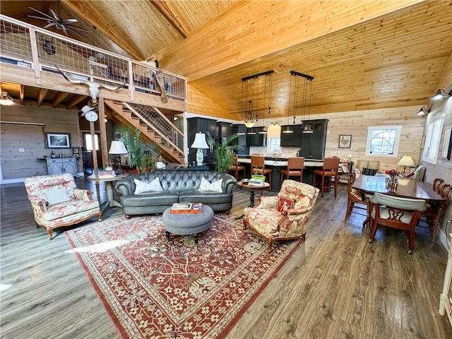 living room featuring wooden ceiling, wood finished floors, stairs, wood walls, and high vaulted ceiling