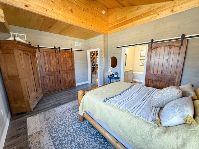 bedroom featuring lofted ceiling, a barn door, wood walls, and wood ceiling