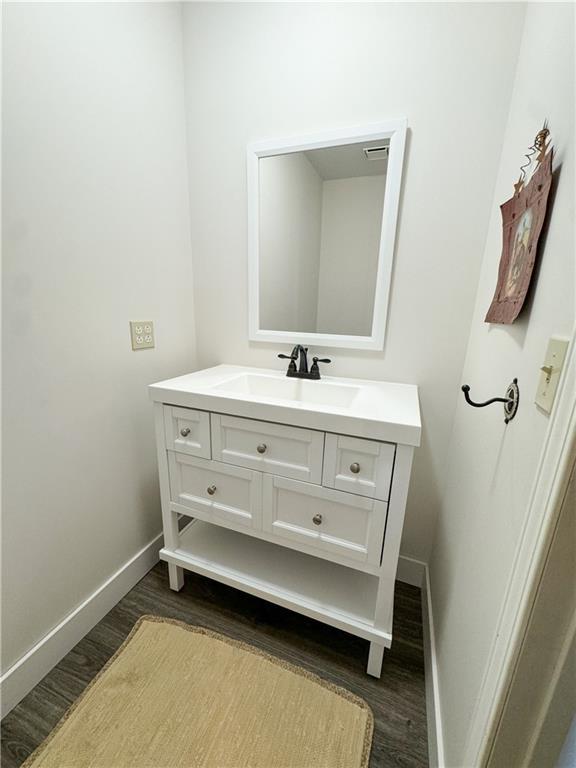 bathroom featuring wood finished floors, vanity, and baseboards