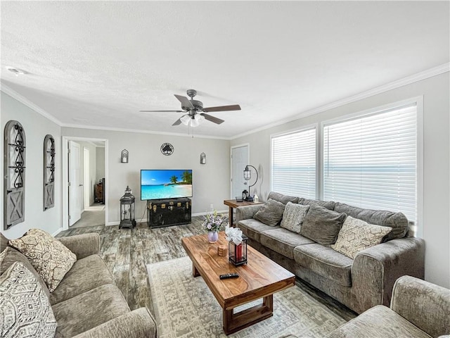 living room with baseboards, a ceiling fan, ornamental molding, wood finished floors, and a textured ceiling