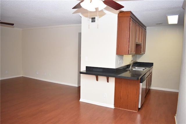 kitchen featuring dark wood-type flooring, a textured ceiling, stainless steel dishwasher, kitchen peninsula, and ceiling fan