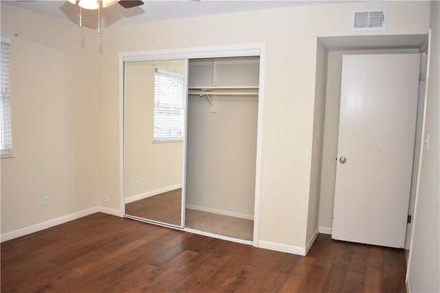 unfurnished bedroom featuring dark wood-type flooring and a closet