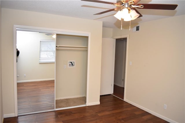 unfurnished bedroom with dark wood-type flooring, ceiling fan, and a closet