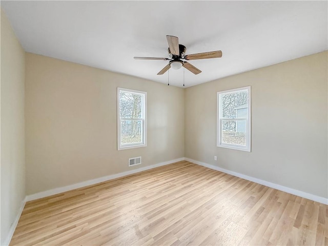 unfurnished room with plenty of natural light, baseboards, visible vents, and light wood-type flooring