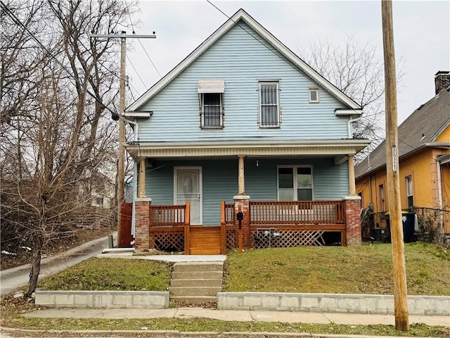 view of front of house with a front yard and a porch