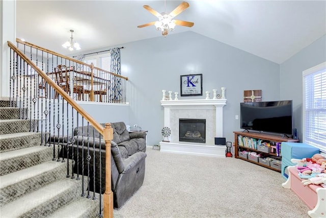 living area with stairs, carpet floors, lofted ceiling, and a fireplace