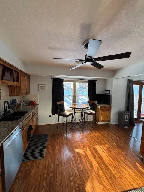 kitchen featuring dishwasher, sink, dark hardwood / wood-style flooring, ceiling fan, and a textured ceiling