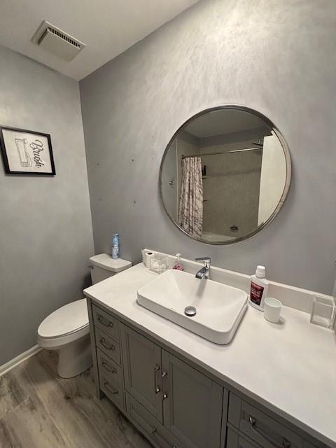 bathroom featuring hardwood / wood-style flooring, vanity, toilet, and a shower with curtain