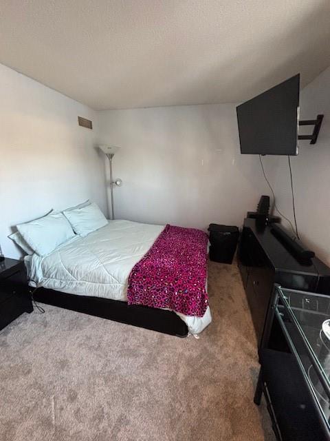 carpeted bedroom with a textured ceiling