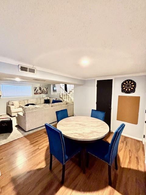 dining space with hardwood / wood-style flooring and a textured ceiling