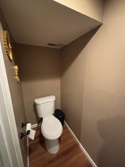 bathroom featuring hardwood / wood-style floors and toilet