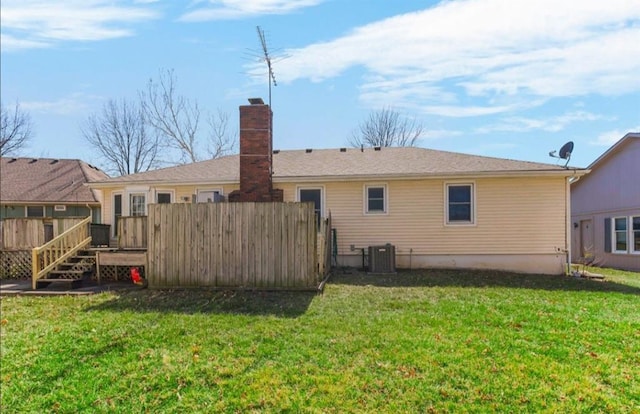 back of property featuring fence, central air condition unit, a wooden deck, a lawn, and a chimney