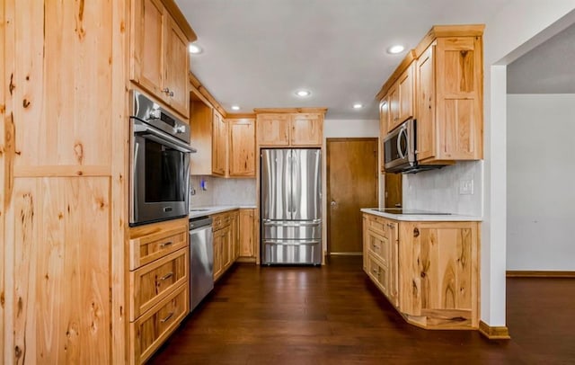 kitchen featuring light brown cabinets, tasteful backsplash, stainless steel appliances, light countertops, and dark wood-style flooring