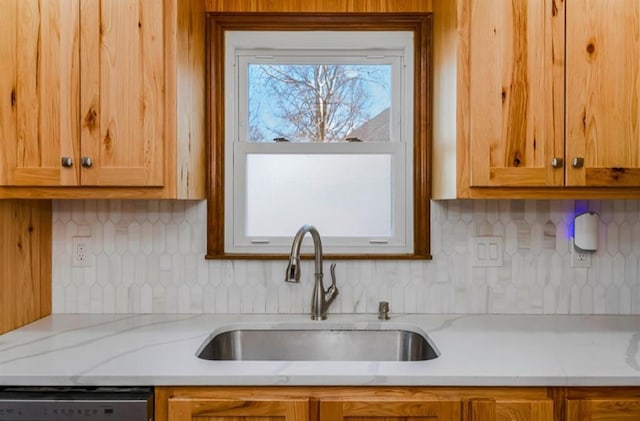 kitchen with tasteful backsplash, dishwashing machine, and a sink