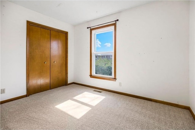 unfurnished bedroom featuring a closet, baseboards, and carpet floors