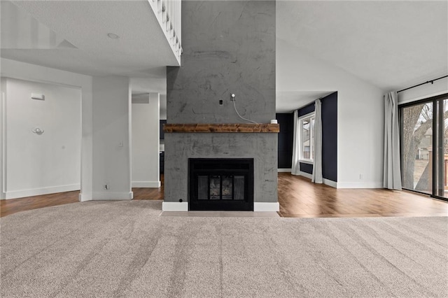 unfurnished living room with lofted ceiling, hardwood / wood-style flooring, and a fireplace