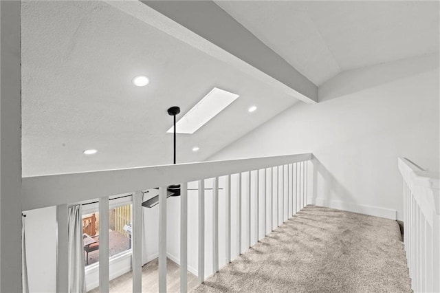 stairs with carpet flooring and vaulted ceiling with skylight