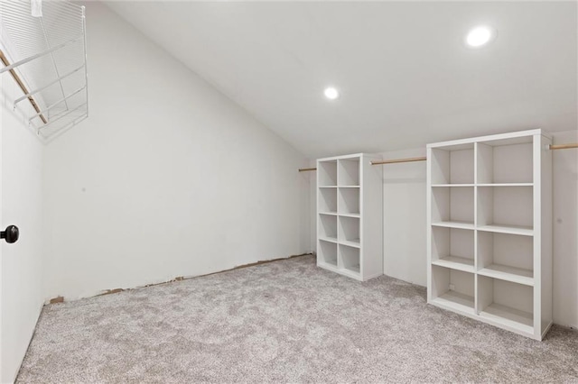 spacious closet with vaulted ceiling and light colored carpet