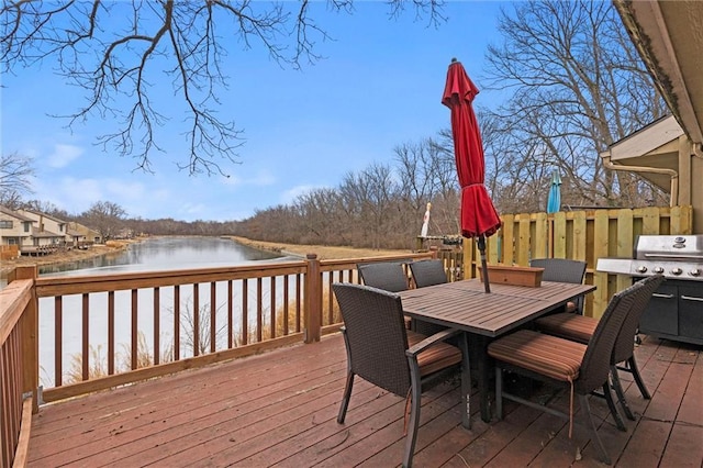 deck with a water view, area for grilling, and outdoor dining space