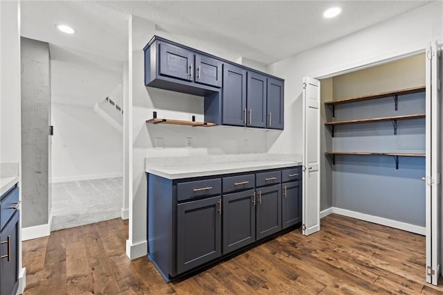 kitchen featuring open shelves, dark wood-style floors, recessed lighting, light countertops, and baseboards