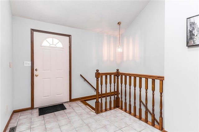 foyer featuring lofted ceiling and baseboards