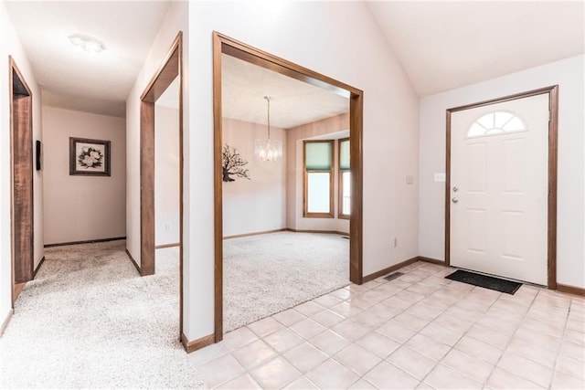 entrance foyer featuring light carpet, a notable chandelier, baseboards, and lofted ceiling