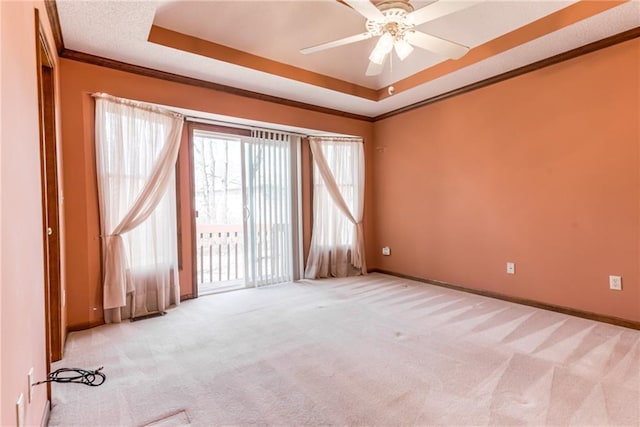 unfurnished room with baseboards, a raised ceiling, carpet, and ornamental molding