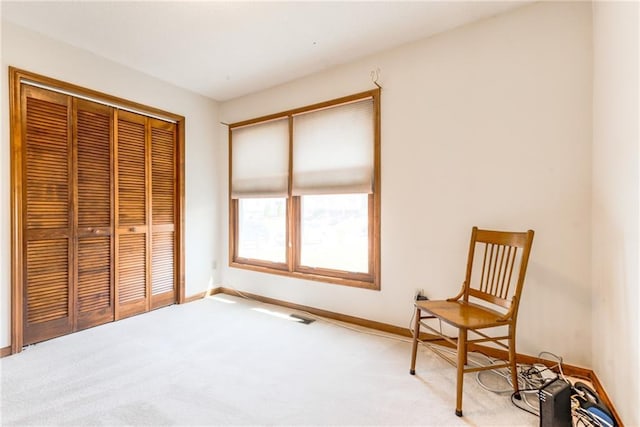 living area featuring carpet and baseboards