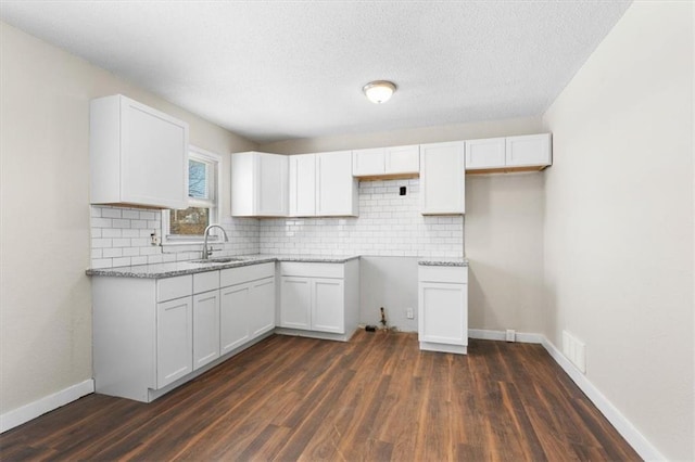 kitchen featuring white cabinetry, sink, decorative backsplash, and dark hardwood / wood-style floors