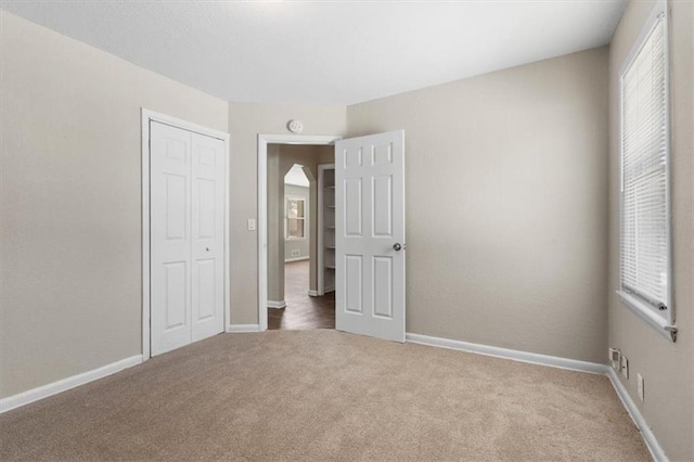 unfurnished bedroom featuring carpet floors and a closet