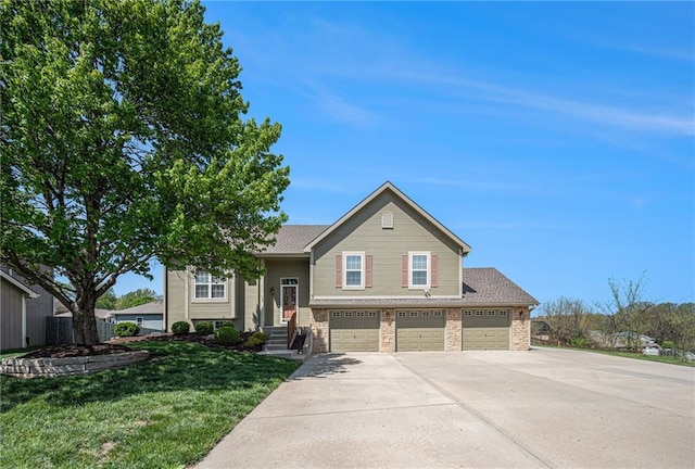 split foyer home featuring driveway, a garage, and a front yard