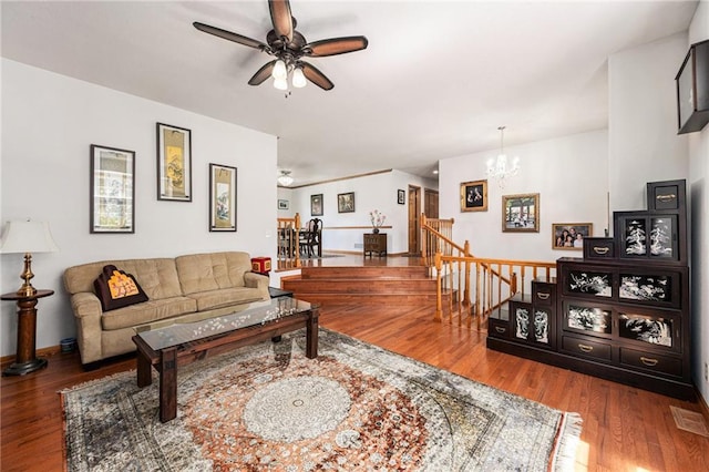 living area featuring ceiling fan, a chandelier, wood finished floors, and baseboards