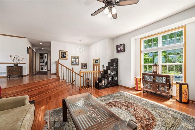living room featuring a chandelier, wood finished floors, and a ceiling fan