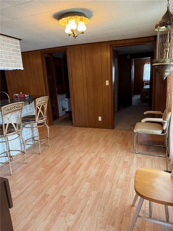 dining room featuring wooden walls and light wood-type flooring