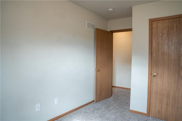 unfurnished bedroom featuring light carpet, visible vents, and baseboards