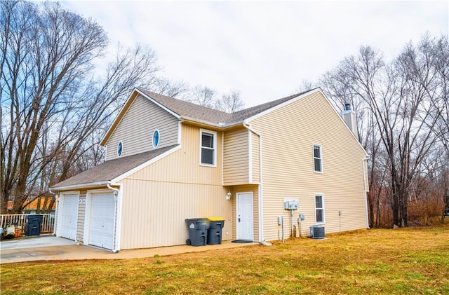 view of home's exterior with an attached garage, central air condition unit, a lawn, and concrete driveway