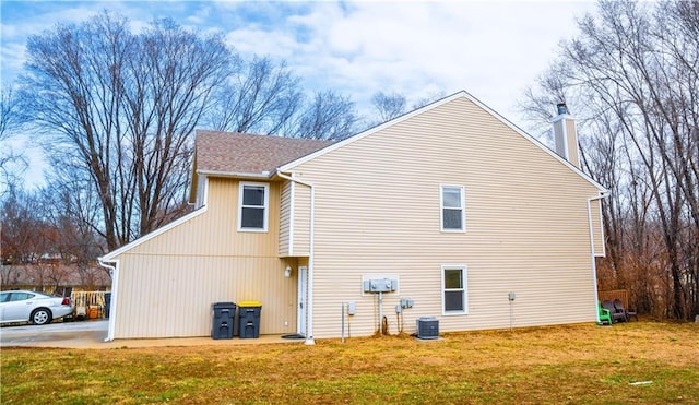 view of property exterior featuring central air condition unit, a chimney, and a lawn