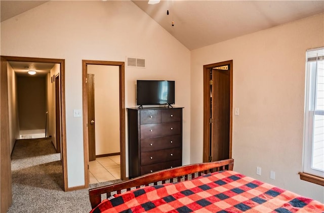 unfurnished bedroom featuring lofted ceiling, light colored carpet, visible vents, and light tile patterned flooring